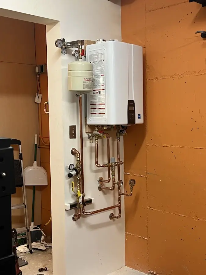 Plumbing technician inspecting water heater connections in Urbana
